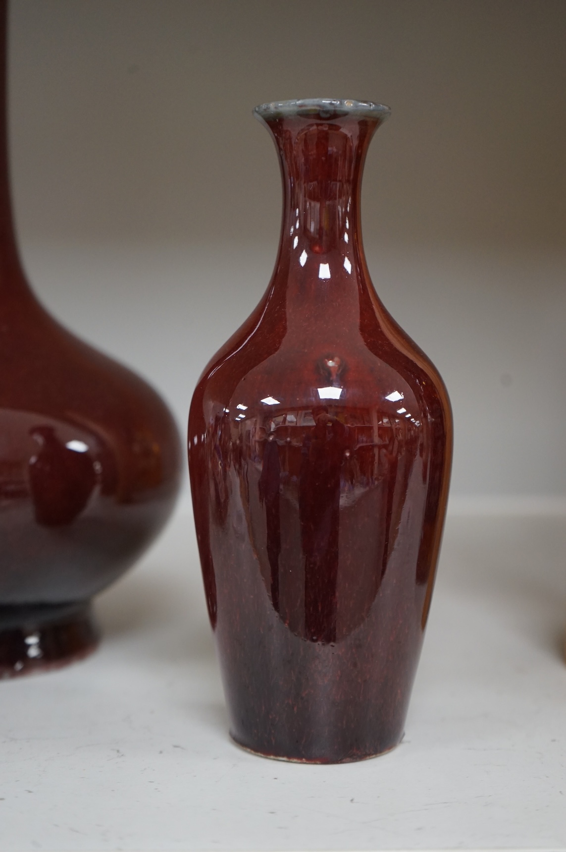 Two Chinese Sang de Boeuf glazed vases to include a bottle neck example, largest 27cm high